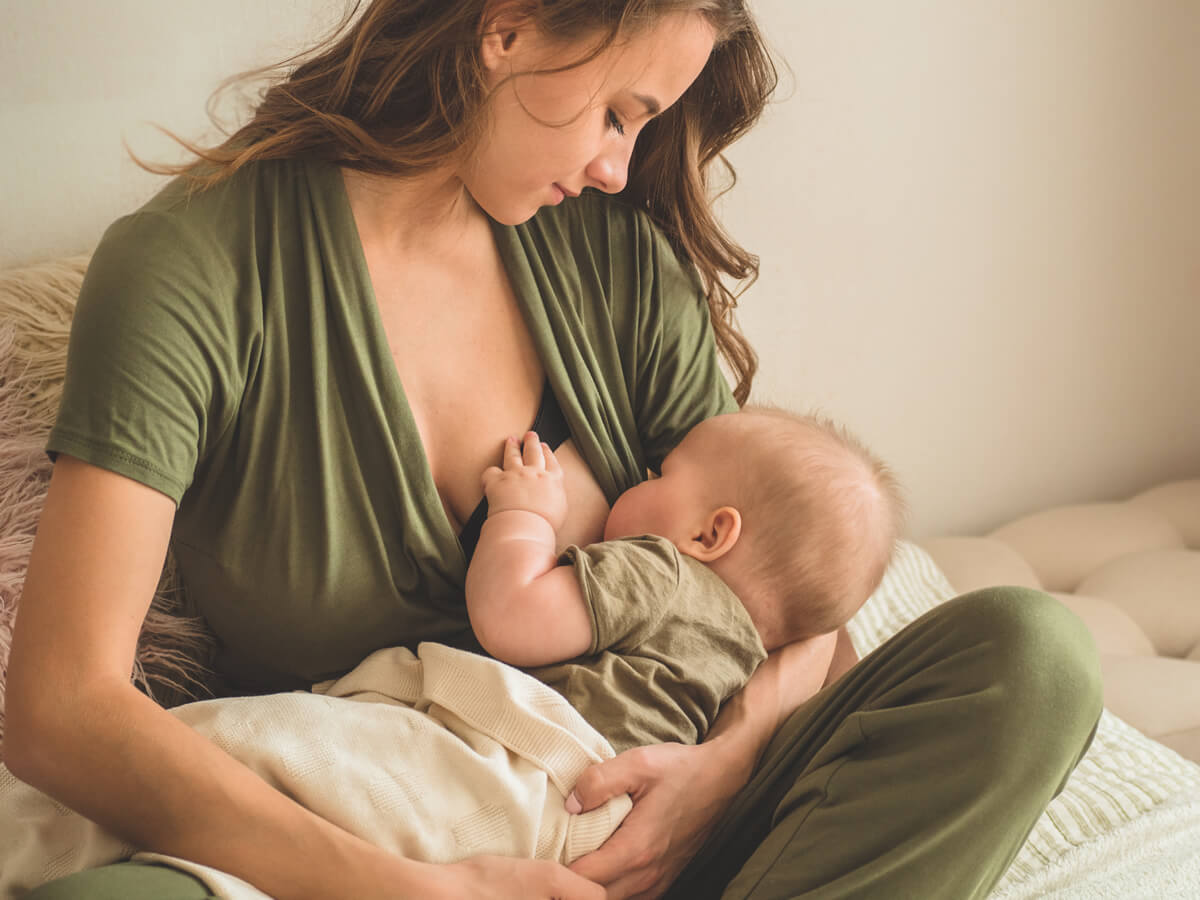 Mother breastfeeding newborn with postpartum lactation support